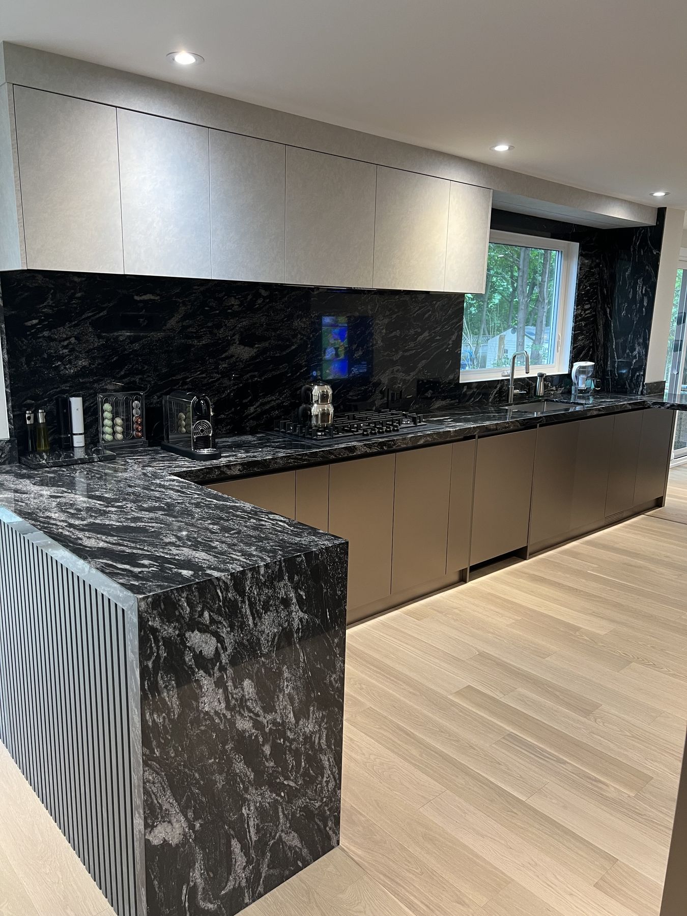 Finished kitchen with a stone island and flat-panel cabinets